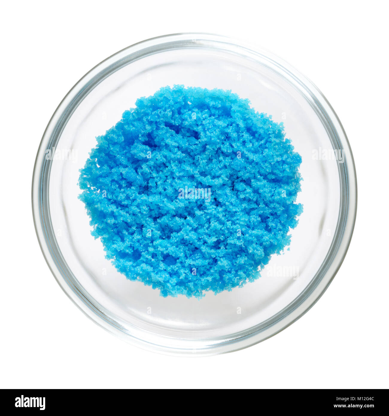 En sulfate cuivrique bol en verre, isolé sur fond blanc. Bleu lumineux du sulfate de cuivre CuSO4, aussi vitriol bleu ou pierre bleue. Le sel. Photo. Banque D'Images