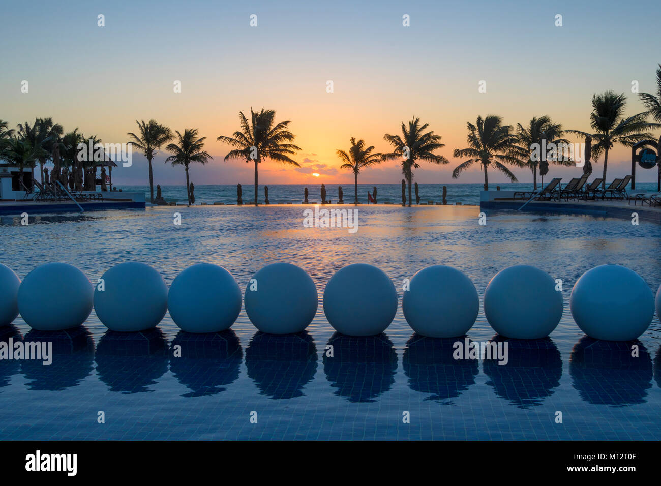 Piscine au lever du soleil, Grand Residences Riviera Cancun, Riviera Maya, Puerto Morelos, Quintana Roo, Yucatan, Mexique. Banque D'Images