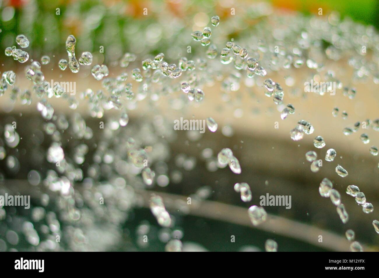 Les petites gouttes d'eau brillantes et d'une fontaine Banque D'Images