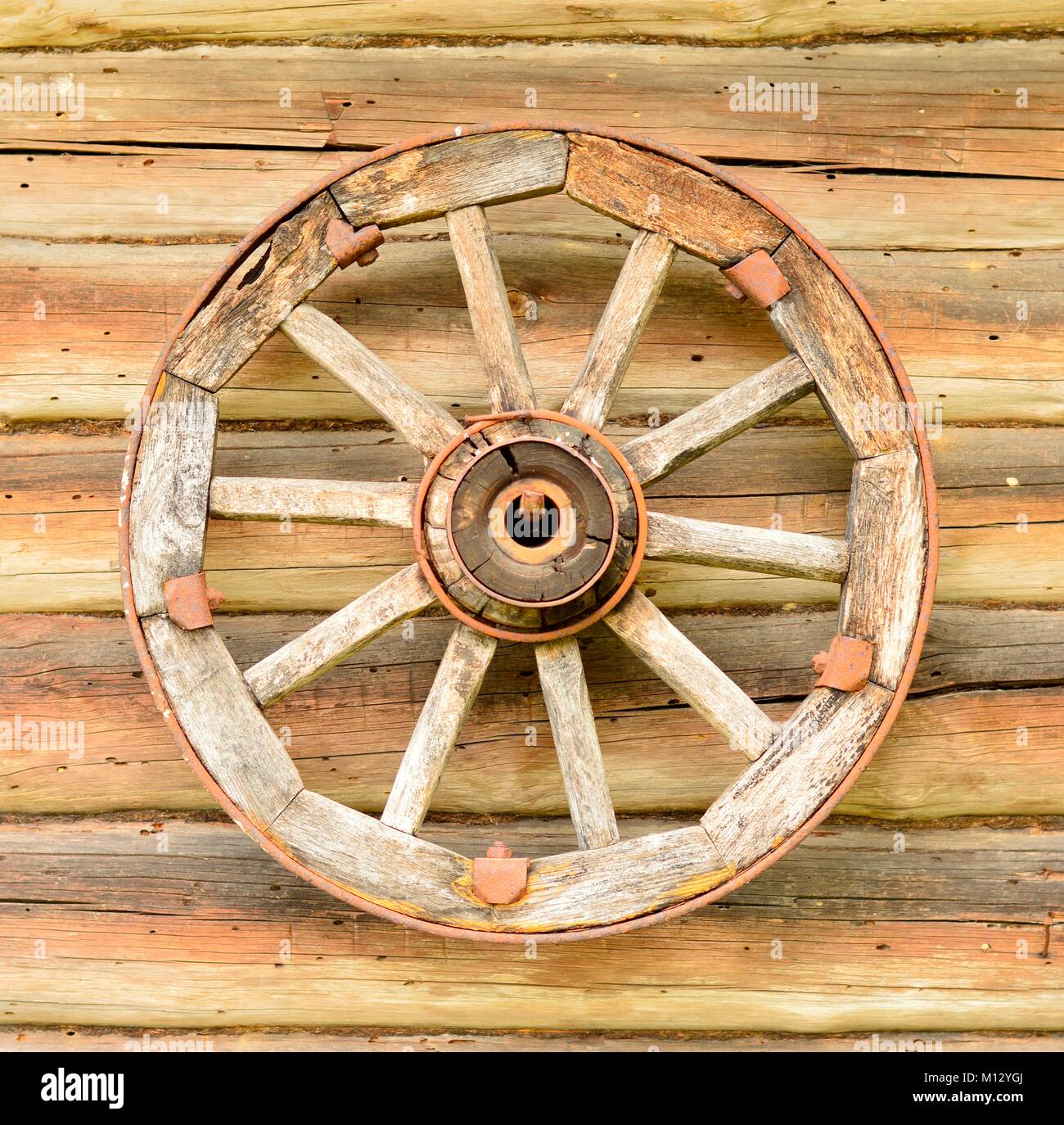Une vieille roue sur un log mur Banque D'Images