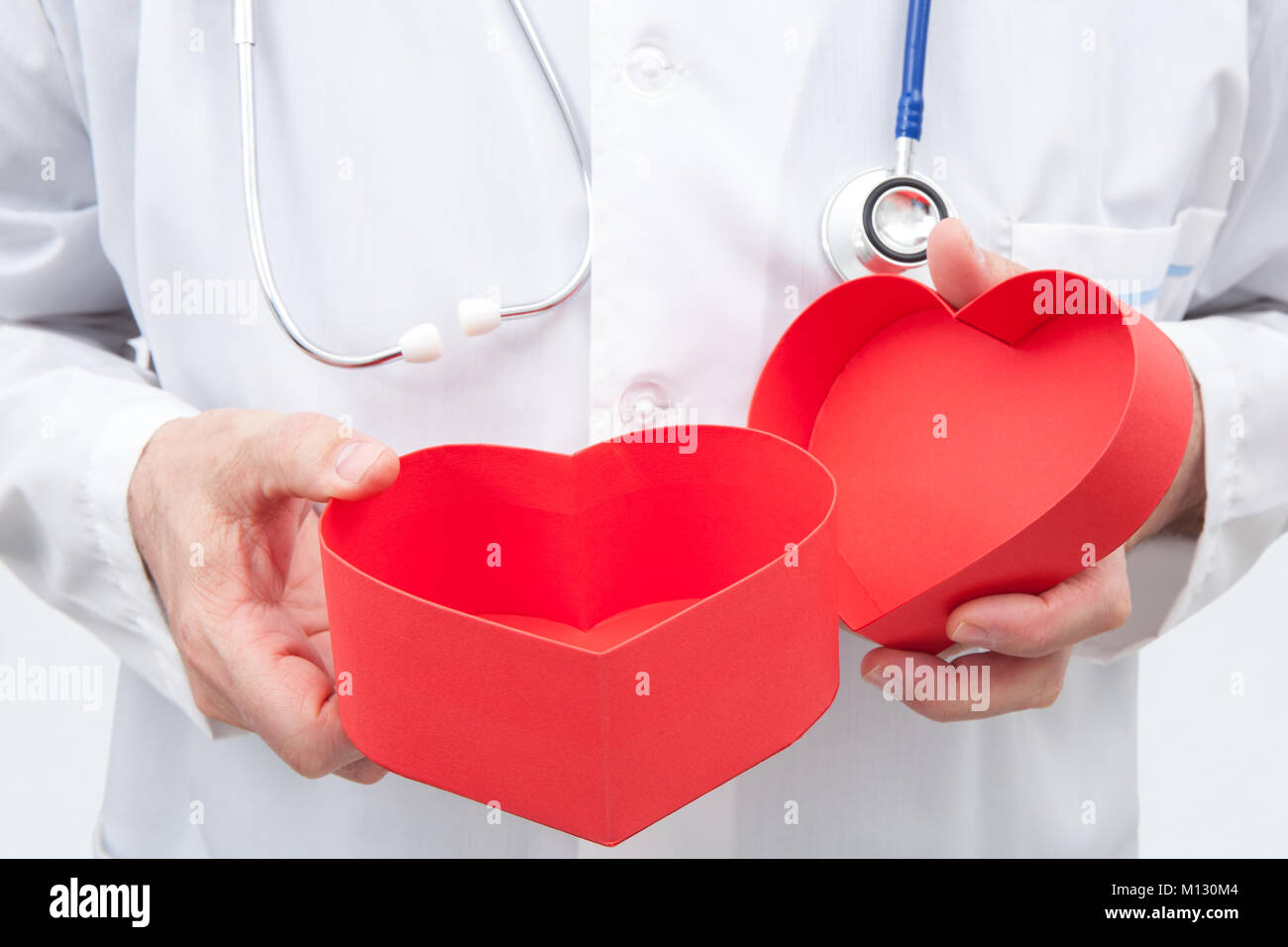 Médecin avec une boîte cadeau rouge avec forme de coeur dans ses mains Banque D'Images