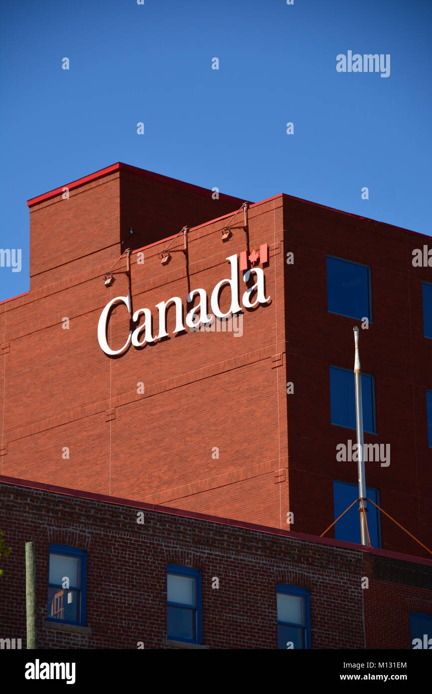 Immeuble en briques avec signe officiel du Gouvernement 'Canada' en face d'un ciel bleu. Banque D'Images