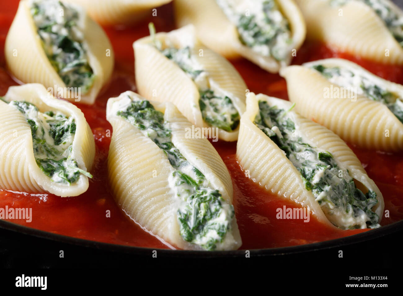 Pâtes conchiglioni farci aux épinards et ricotta macro sur une plaque horizontale. Banque D'Images