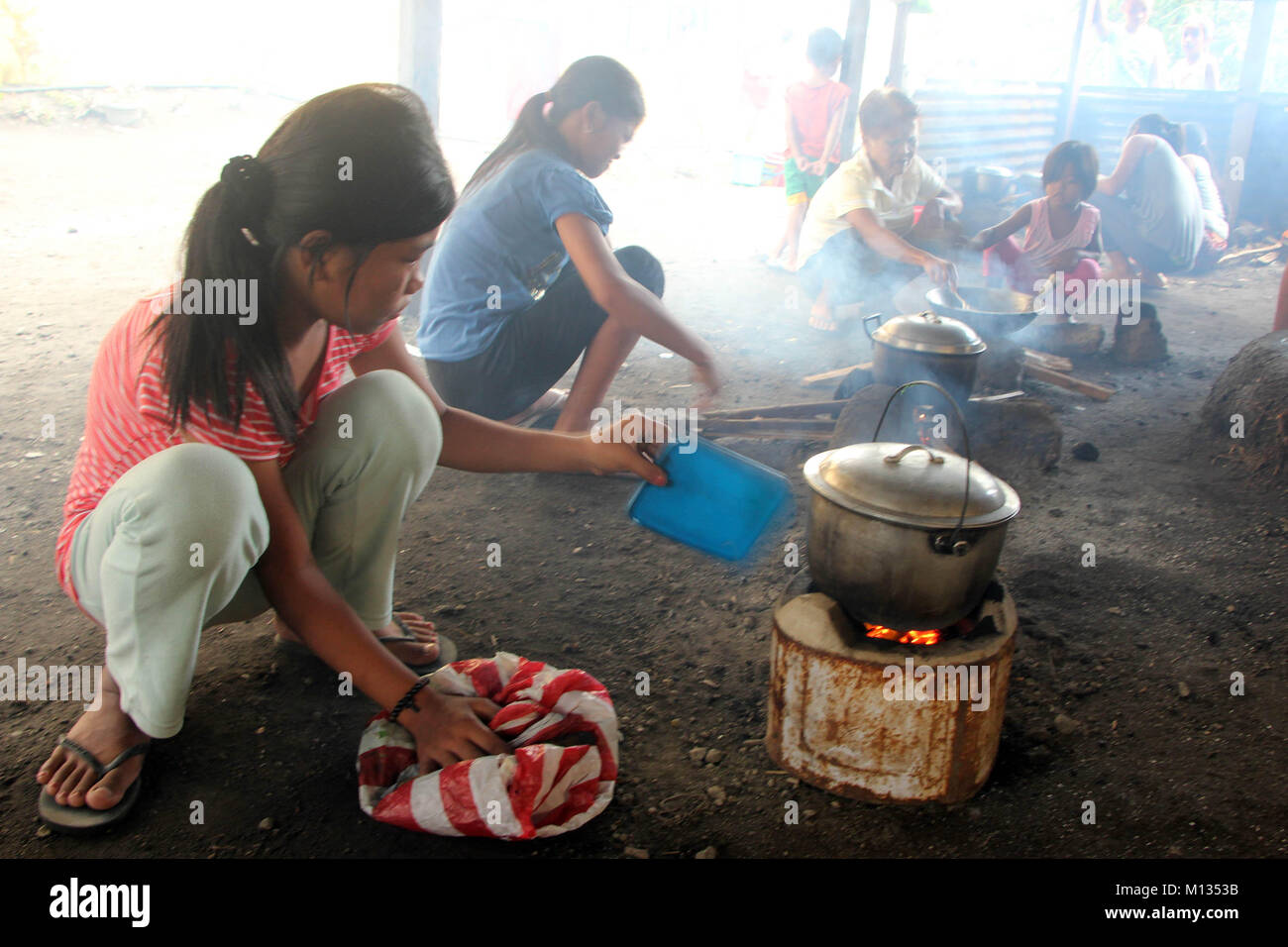 Les personnes évacuées pendant la cuisson des aliments à l'aide l'woodsfrom Brgy. Dans Baligong Ligao City National Technical Vocational High School, LigaoCity Albay Bicol, le 26 janvier 2018. L'Institut philippin de volcanologie et de Sismologie (PHILVOLCS) numéro d'alerte déclarée 8 et plus large de la zone de danger à 8 kilomètres après l'explosion continue du volcan activités active ce passé plusieurs jours. Selon les rapports, c'est un total de 74 000 personnes sont touchées et 100 millions de dollars de dommages-intérêts dans les terres agricoles conformément à Ministère de l'Agriculture (DAR). (Photo par Gregorio B. Dantes Jr./ Banque D'Images