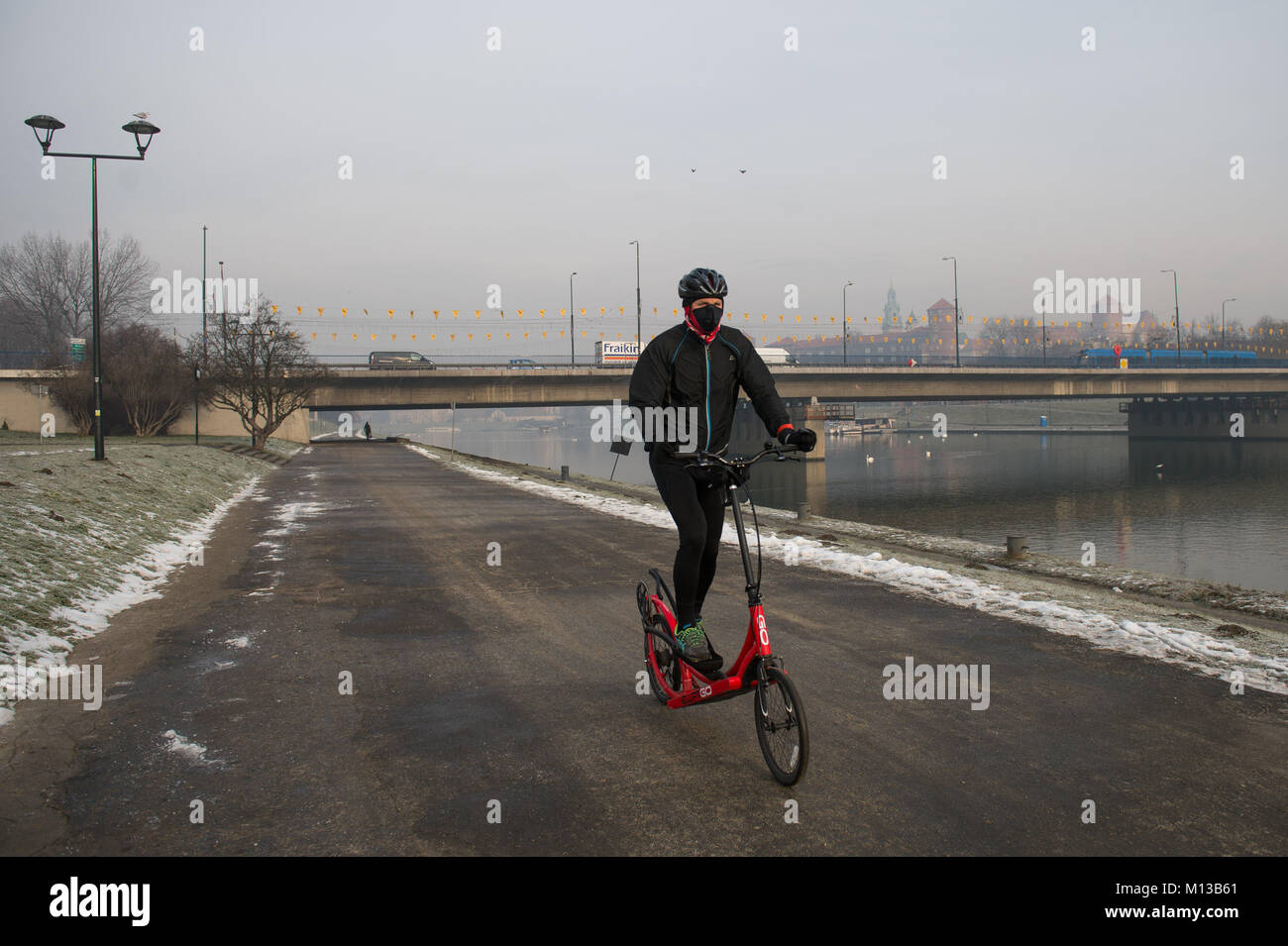 Cracovie, Pologne. 26 janvier, 2018. Un homme porte un masque anti smog comme il conduit une bicyclette à Cracovie. Aujourd'hui, le niveau de PM 10 est de 136 ?g/m3. Credit : Omar Marques/SOPA/ZUMA/Alamy Fil Live News Banque D'Images