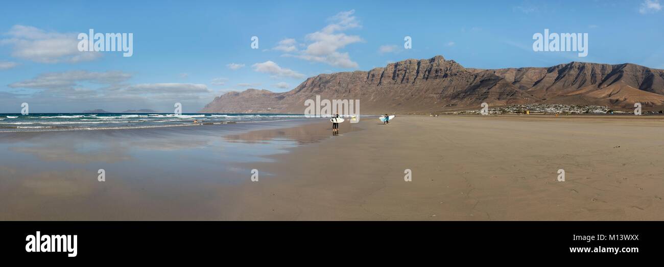 Espagne, Canaries, l'île de Lanzarote, Caleta de Famara, les surfeurs sur la plage de Famara avant le Risco de Famara cliff Banque D'Images
