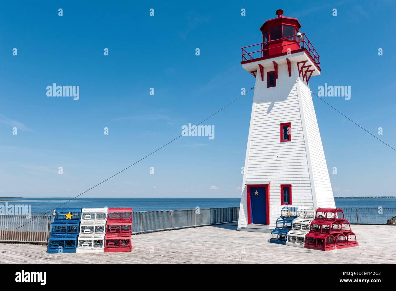 Canada, Nouveau-Brunswick, Shippagan, Phare et des casiers à homard dans les couleurs de l'Acadie, bleu, blanc, rouge et jaune star Banque D'Images