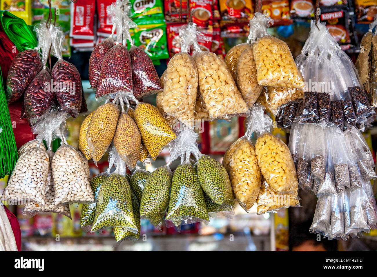 Des sacs en plastique remplis d'une variété colorée des pois, des haricots, des pâtes et des épices se bloquer dans la fonction d'interrogation à Barretto, Luzon, Philippines. Banque D'Images