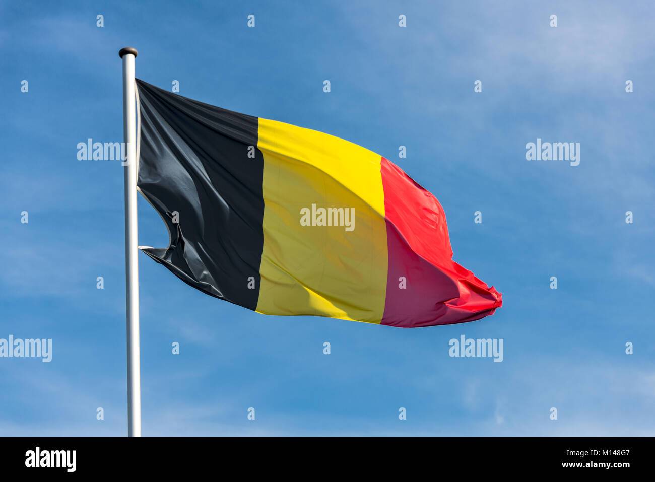 Gros plan du seul drapeau belge frétillement dans le vent en face de ciel bleu Banque D'Images