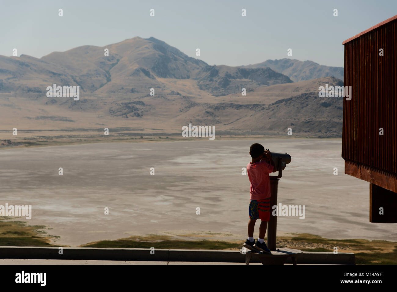 Un jeune garçon utilise un champ pour afficher le Grand Lac Salé de White Rock Bay, Antelope Island, Utah, USA. Banque D'Images