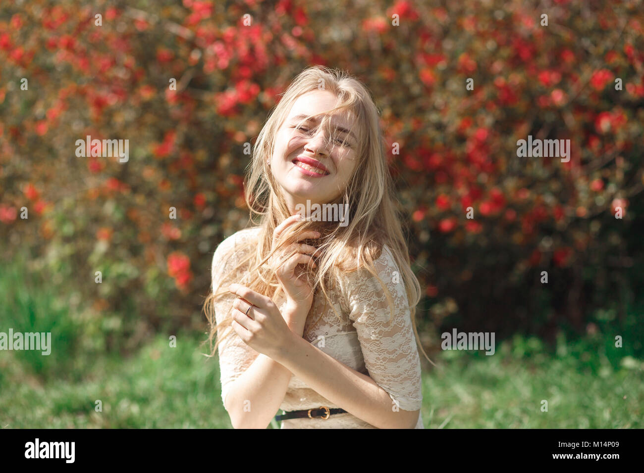 Belle jeune femme admirant journée ensoleillée dans le parc pendant la saison des fleurs sur une belle journée de printemps. Banque D'Images