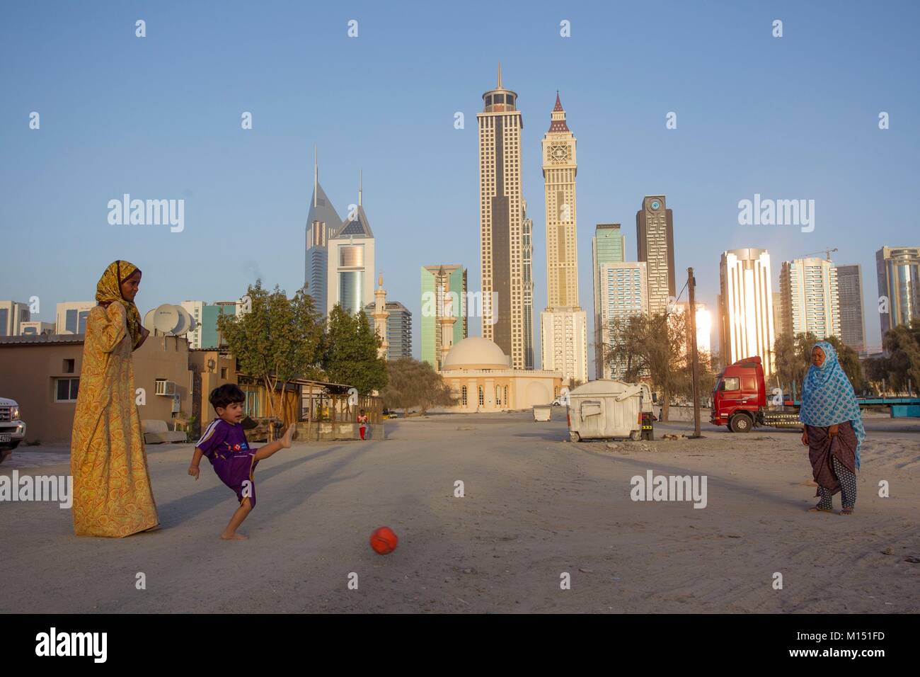 Emirats Arabes Unis, Dubaï, Sheikh Zayed towers et les femmes jouent au football avec bébé Banque D'Images