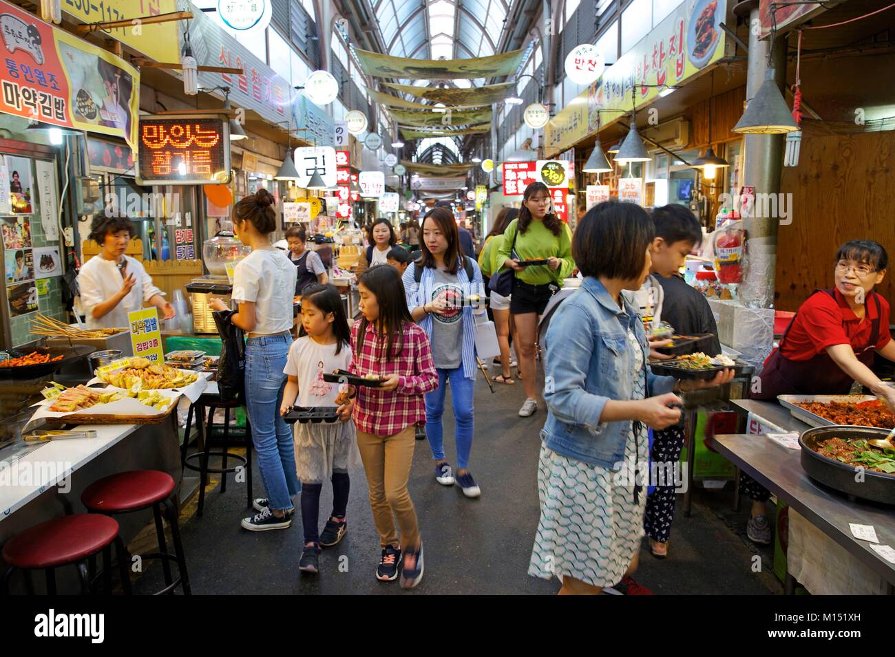 La Corée du Sud, Séoul, les familles avec les bacs avec des plats coréens dans le Tong-in market Banque D'Images