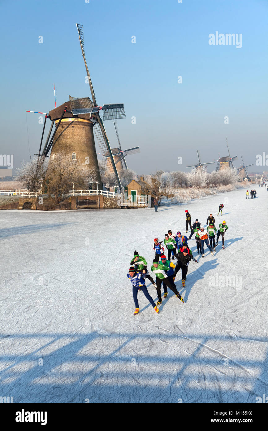 Les Pays-Bas, Kinderdijk, Moulins, Patrimoine Mondial de l'Unesco. Les gens du patinage sur glace. L'hiver. Banque D'Images