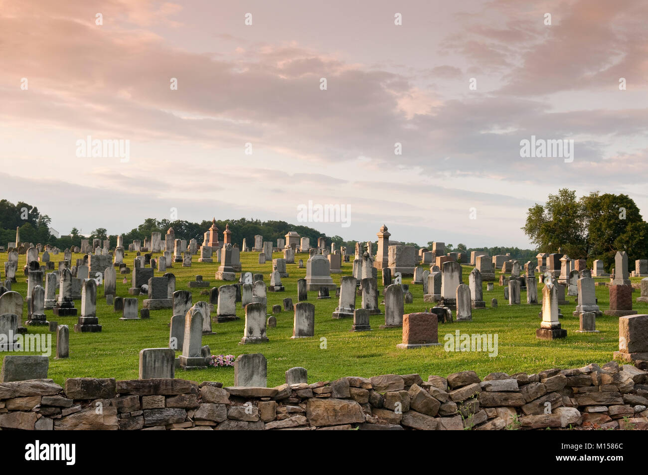 Cimetière rural pleines d'anciennes pierres tombales situé sur la colline derrière le mur en pierres pittoresque Banque D'Images