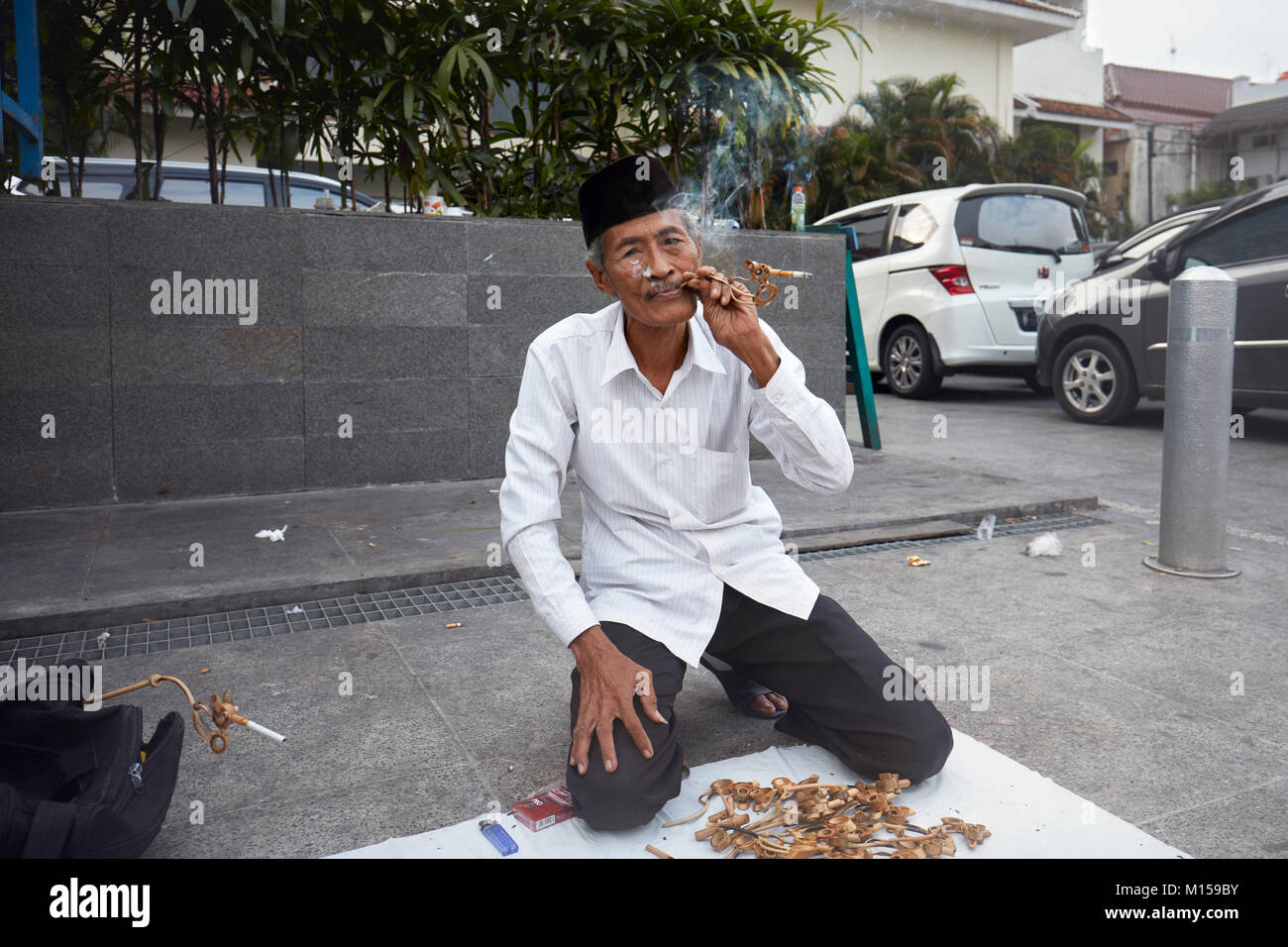 Vendeur de rue vendant des fume-cigarettes en bois faits à la main sur la rue Malioboro. Yogyakarta, Java, Indonésie. Banque D'Images