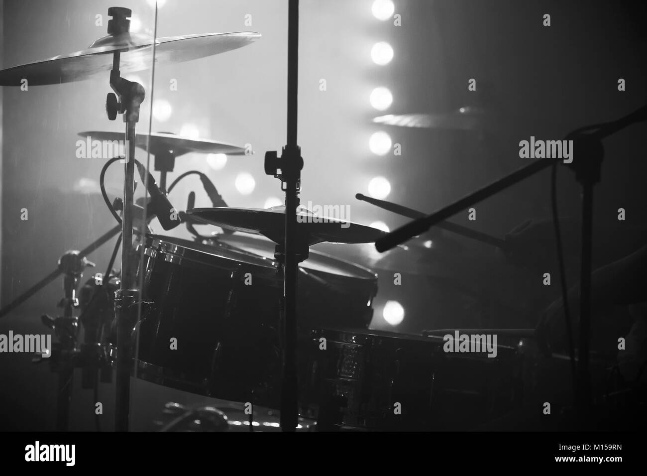 Photo de la musique live, un ensemble de batterie avec cymbales et feux de scène sur un arrière-plan, le noir et blanc Banque D'Images