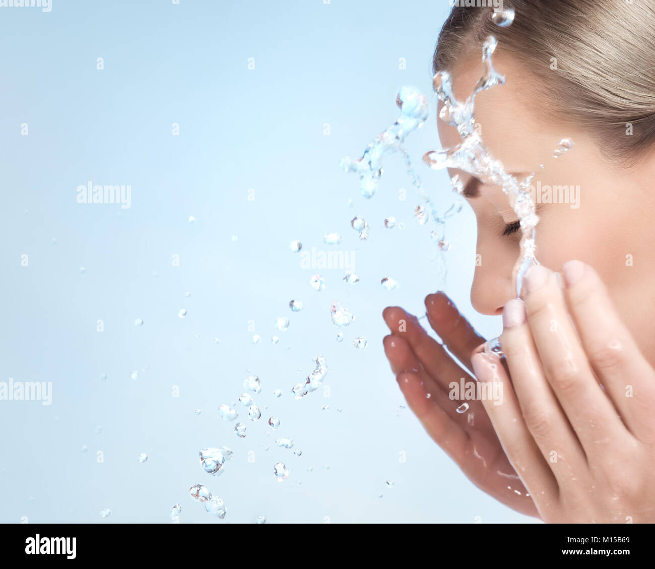 Une femme se lave le visage avec de l'eau froide, la peau après le  nettoyage, à l'aide de maquillage anti acné ou agent anti de  vieillissement, de soins et de soins de