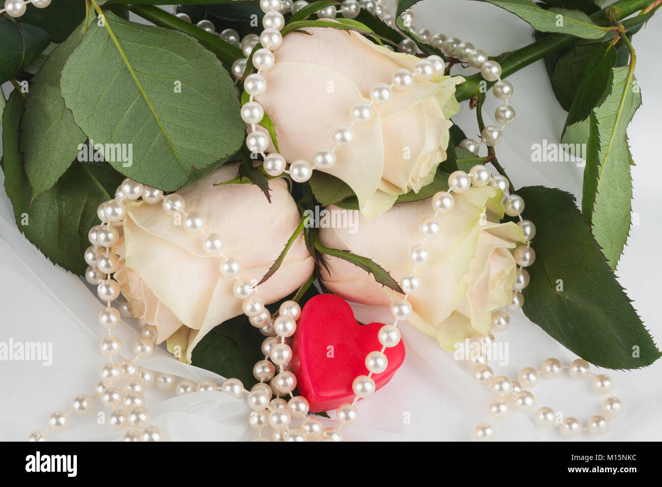 Coeur rouge entourée de roses et de perles. Concept de douce Saint-Valentin Banque D'Images