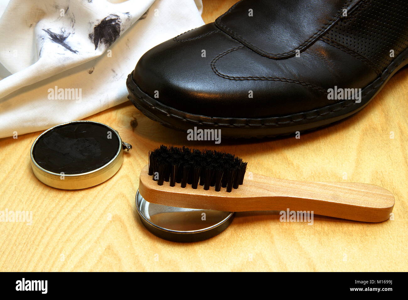 Vue partielle d'une chaussure avec un chiffon de nettoyage, cirage et pinceau. Banque D'Images