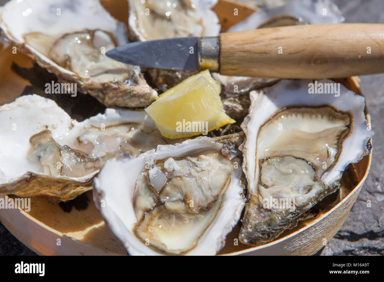 Plateau avec huîtres, citron et couteau à huîtres lors d'une foire de rue, Portbail, Cotentin, la Manche, Normandie, France Banque D'Images