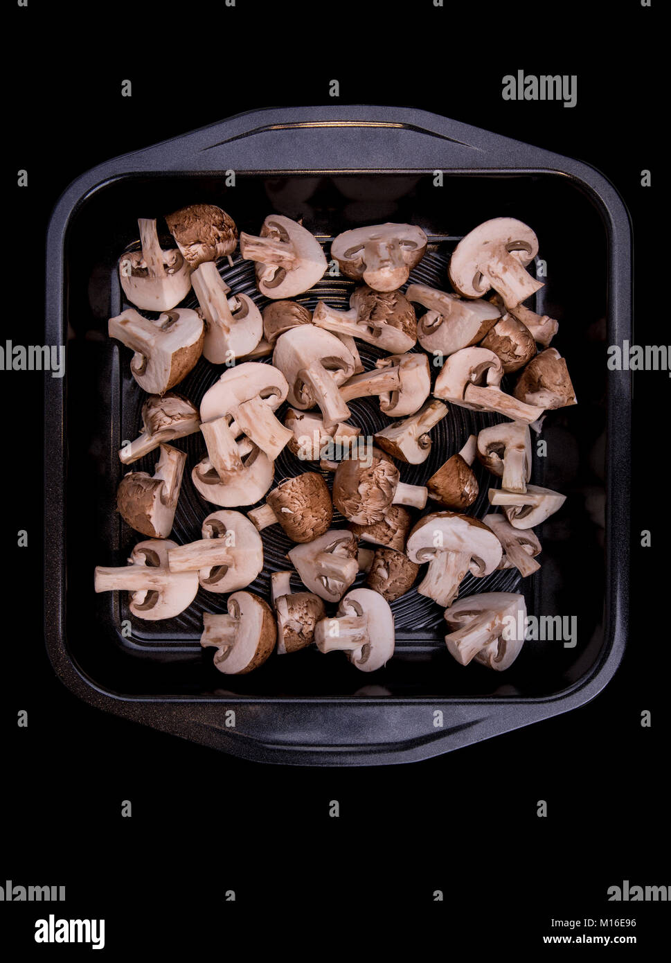 Le bac de champignons coupés sur fond sombre Banque D'Images