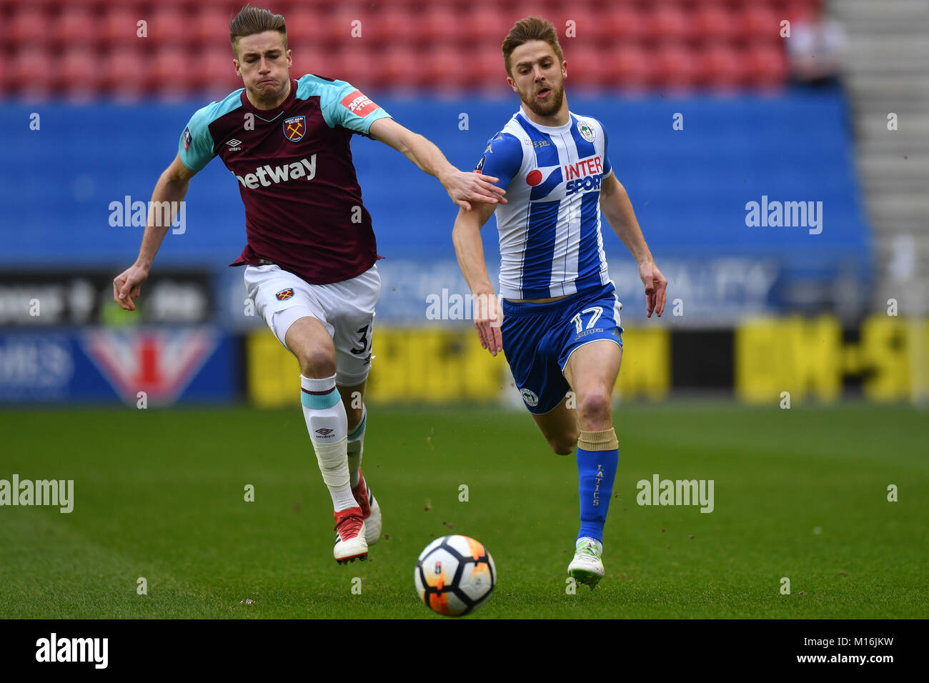 West Ham United's Reece Burke (à gauche) et Wigan Athletic's Michael Jacobs en concurrence pour la possession au cours de l'Emirates en FA Cup, quatrième ronde match à la DW Stadium, Wigan. Banque D'Images