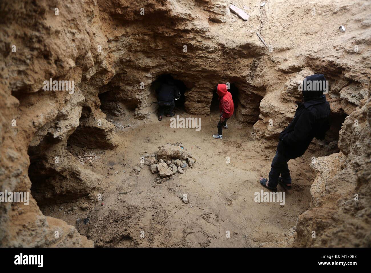 Beit Hanoun, bande de Gaza, territoire palestinien. 28 janvier, 2018. Les Palestiniens se rassembler dans un cimetière fraîchement découvert qui a été trouvé par Abdelkarim al-Kafarna dans son arrière-cour dans la ville de Beit Hanoun, dans le nord de la bande de Gaza le 27 janvier 2018. Selon les experts, les tombes ont été le cadre d'un loculus tombe que peut-être, date de la fin du Roman-Byzantine ère dans le quatrième et le sixième siècle de l'ère où la bande de Gaza a fait partie de l'Empire romain : Crédit Mohammed Asad APA/Images/ZUMA/Alamy Fil Live News Banque D'Images