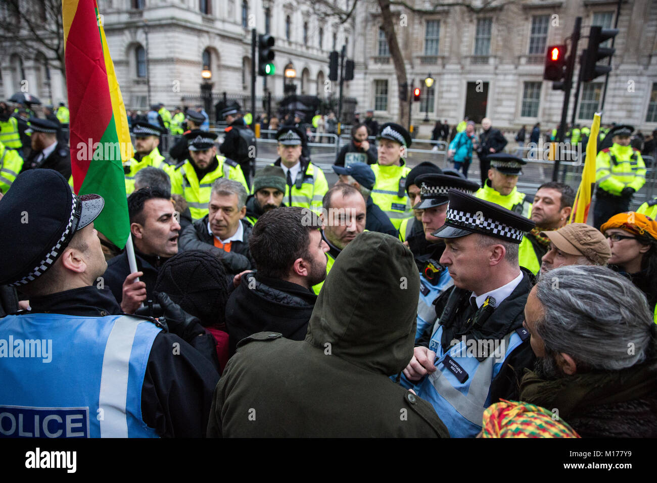 Londres, Royaume-Uni. 27 janvier, 2018. Les fonctionnaires de police interviennent après des manifestants kurdes s'opposent à un homme ayant été détenus soupçonnés d'une infraction en vertu de l'article 13 de la Loi sur le terrorisme après avoir volé un drapeau interdit au cours d'une manifestation en face de Downing Street contre l'offensive militaire de la Turquie dans et autour sous contrôle kurde Afrin en Syrie et contre une déclaration faite par le Ministre britannique des affaires étrangères, Boris Johnson à l'appui de la Turquie. Credit : Mark Kerrison/Alamy Live News Banque D'Images