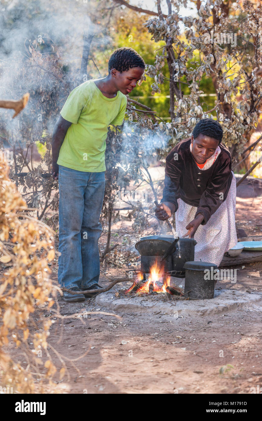 Maman ce qu'est pour le dîner, cuisine cuisson femme africaine dans le village, au Botswana Banque D'Images