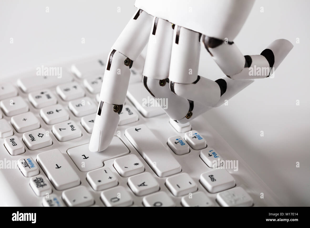 Close-up of main robotique appuyant sur la touche Entrée du clavier Banque D'Images