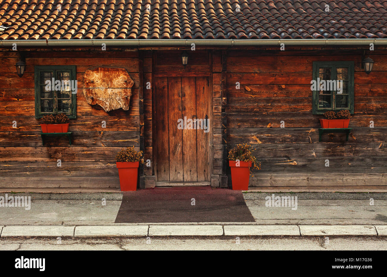 Façade de vieille maison en bois avec fleurs et vases décoratifs. Banque D'Images