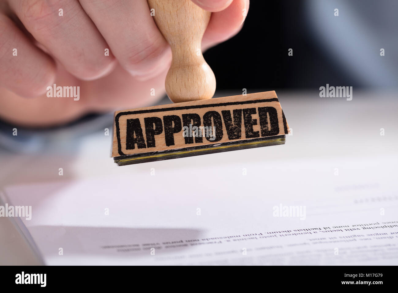 Close-up de l'homme d'affaires à l'aide de la main de Stamper sur Document avec texte approuvé Banque D'Images