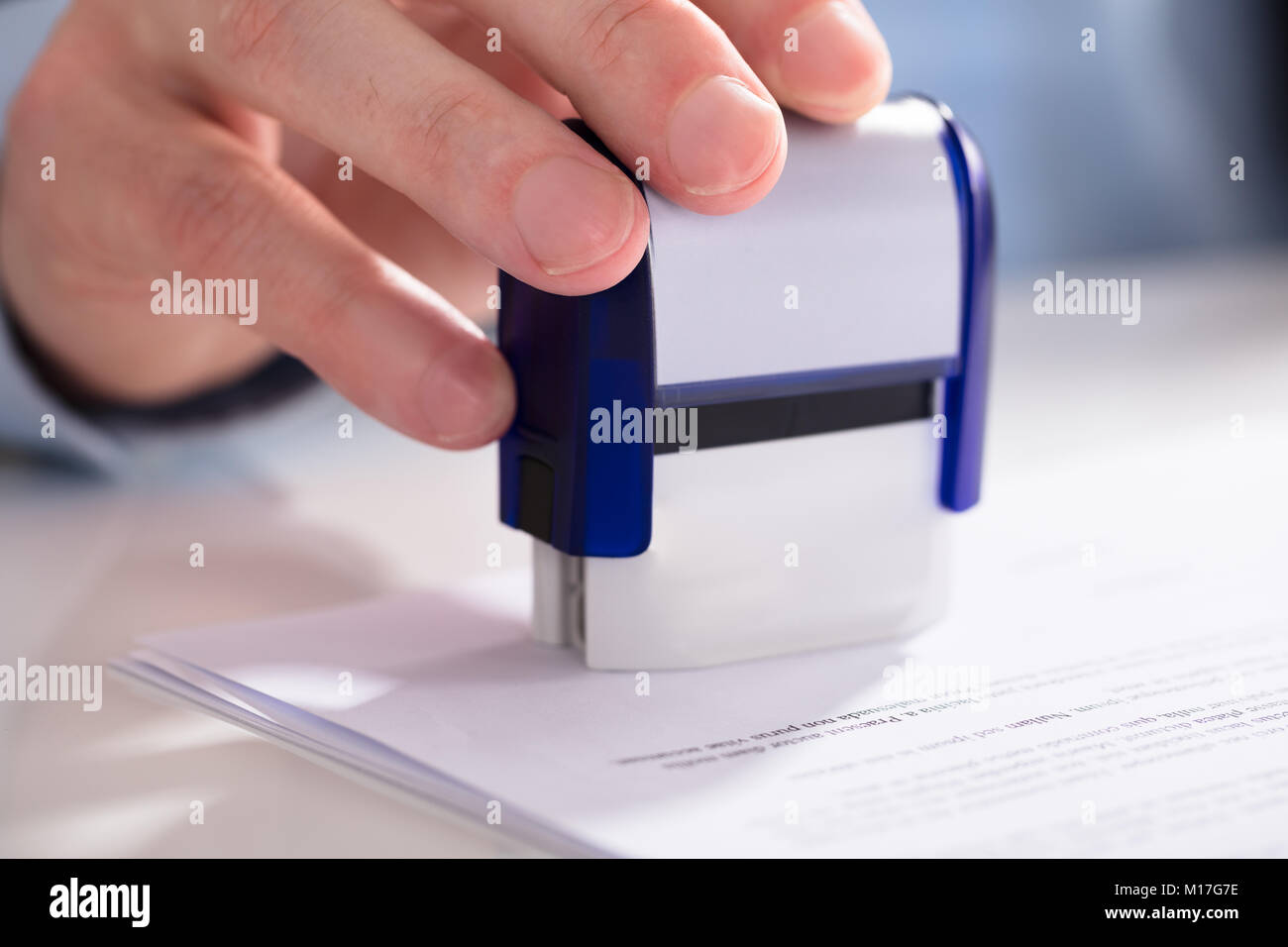 Close-up de l'homme d'affaires à l'aide de la main de Stamper sur le document Banque D'Images