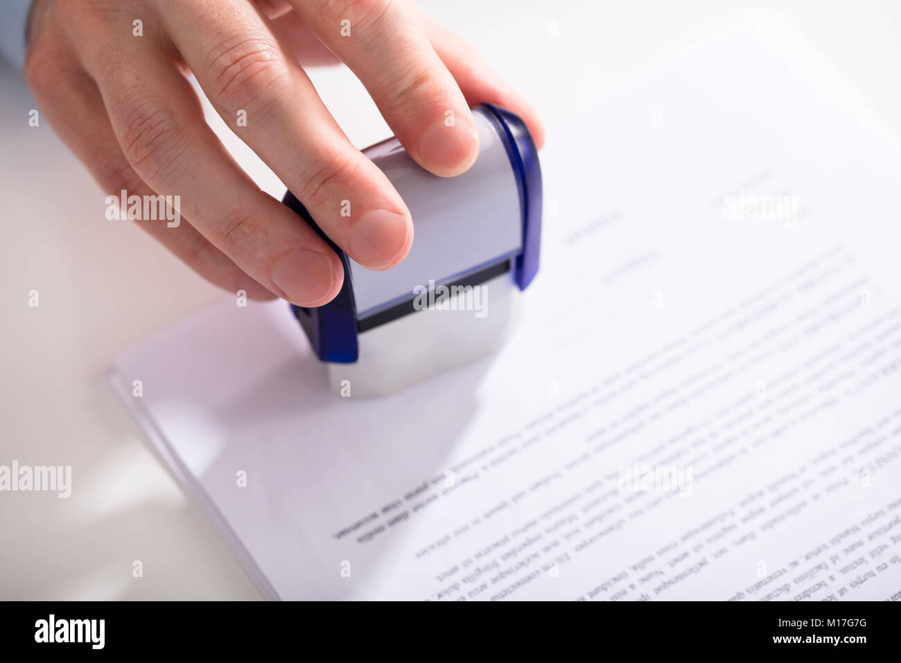 Close-up de l'homme d'affaires à l'aide de la main de Stamper sur le document Banque D'Images