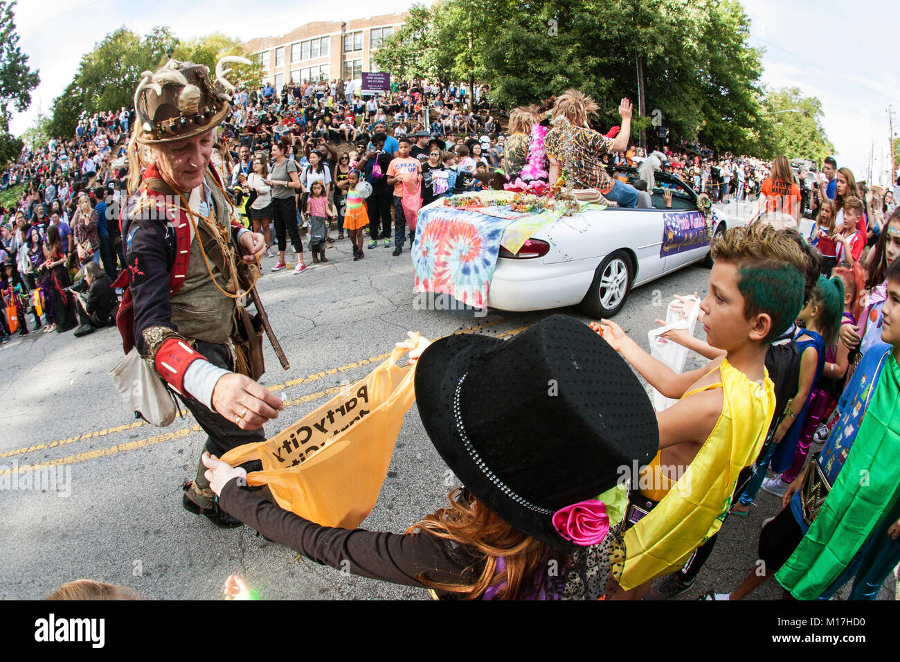 Atlanta, GA, USA - 21 octobre 2017 : un défilé participant décidant des bonbons aux enfants impatients le long du parcours d'un défilé d'Halloween à Atlanta, GA. Banque D'Images