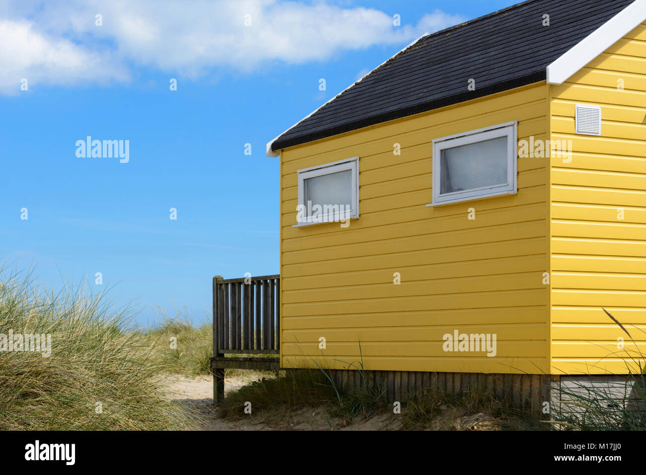 Cabines de plage en bois peint de couleur parmi les dunes de sable de Mudeford Spit, près de Christchurch, Dorset, Angleterre, Royaume-Uni, Europe Banque D'Images