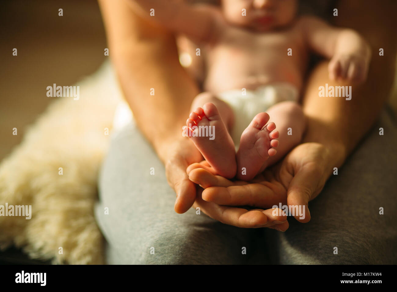 Bébé nouveau-né dans les jambes de Belles Mères part avec soft focus sur le pied d'babie Banque D'Images