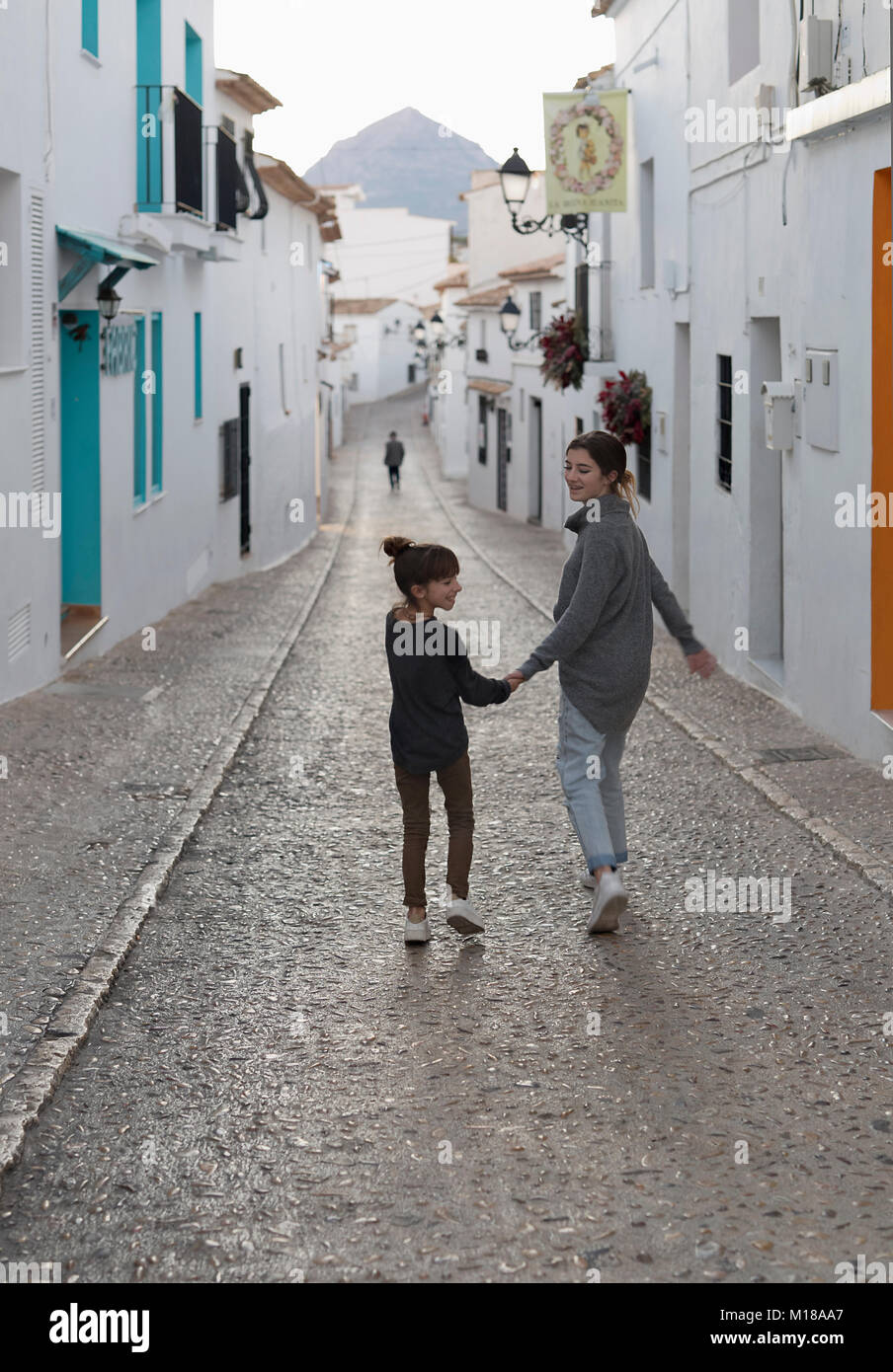 Deux Sœurs marche main dans la main à travers la ville d'Altea, dans la province d'Alicante, Espagne. Banque D'Images