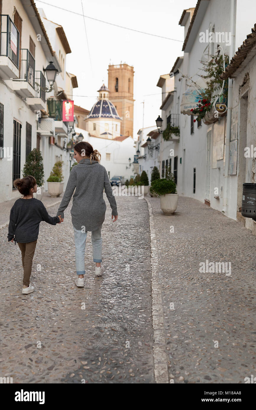 Deux Sœurs marche main dans la main à travers la ville d'Altea, dans la province d'Alicante, Espagne. Banque D'Images