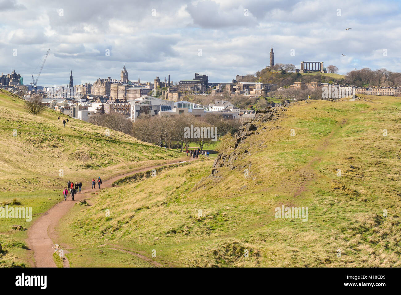 La ville d'Edimbourg à pied - walkers sur sentier menant de Holyrood Park jusqu'à Arthurs Seat et Salisbury crags, avec vue imprenable sur la ville Banque D'Images