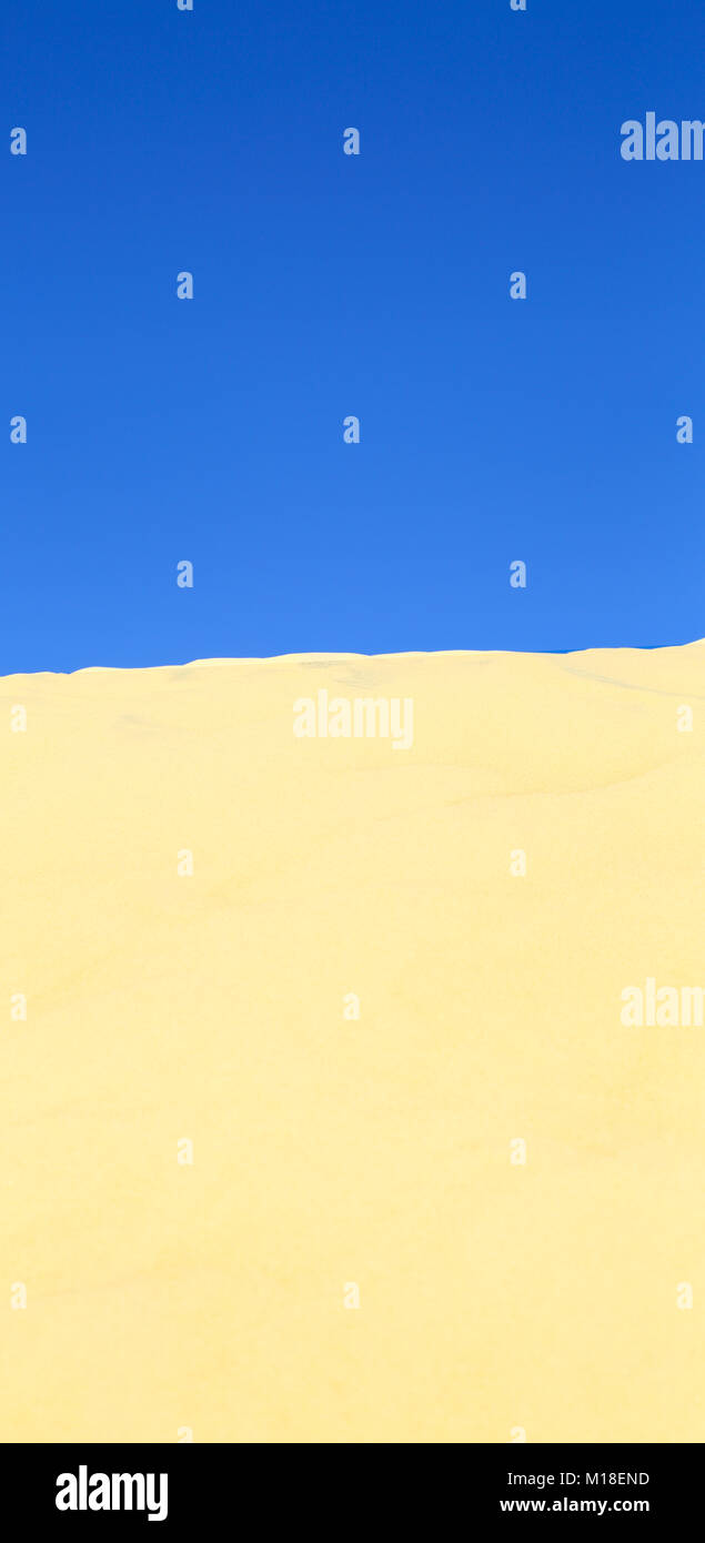 Dune de sable sous un ciel bleu limpide. Banque D'Images