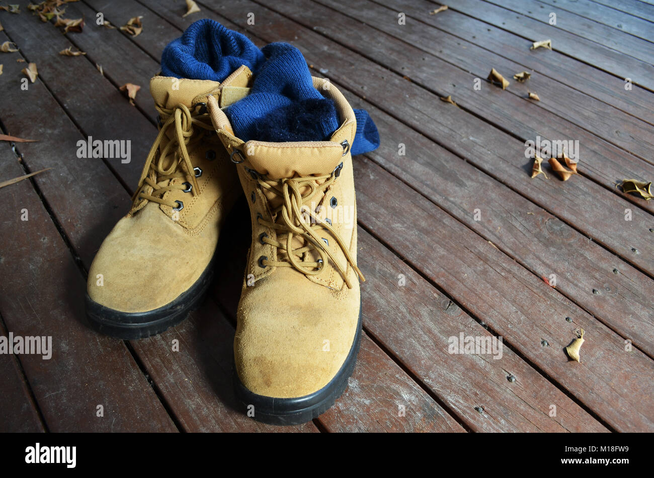 Bottes de travail sur une terrasse en bois Banque D'Images