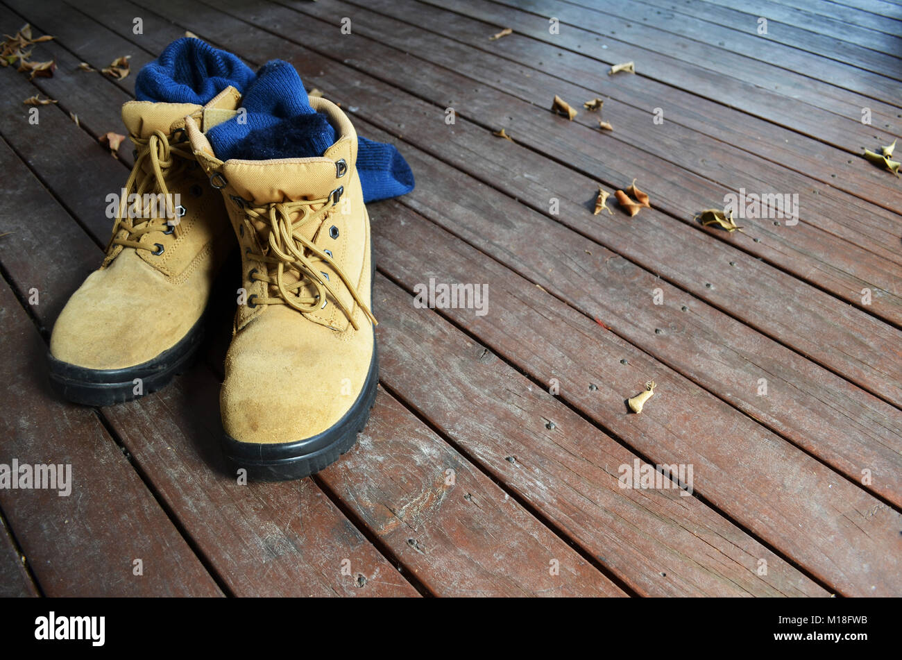 Bottes de travail sur une terrasse en bois Banque D'Images