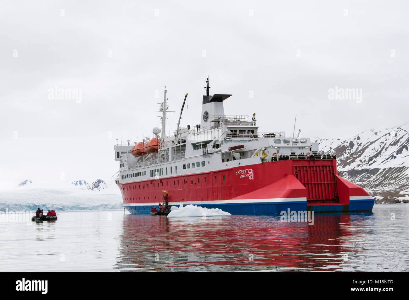 Les passagers des canots à retourner à G Adventures Expedition cruise ship amarré par un glacier dans un fjord. Spitsbergen, Svalbard, Norvège, Scandinavie Banque D'Images
