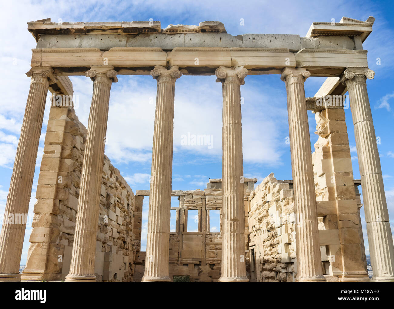 Vue de dessous de l'Erechtheion temple d'Athéna sur l'acropole d'Athènes contre un ciel bleu avec des nuages filandreux Banque D'Images