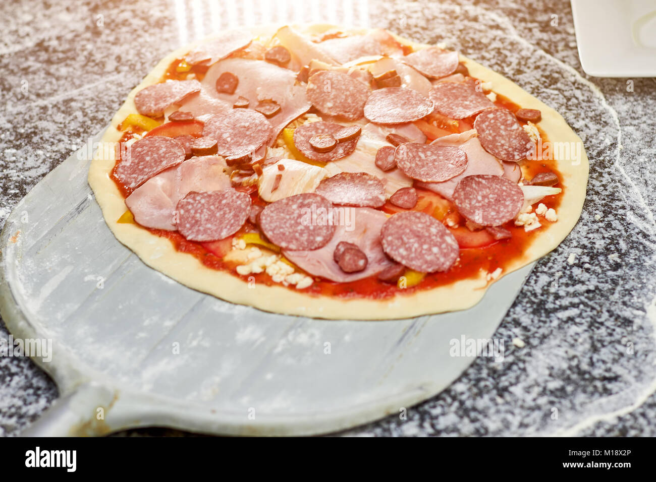Salami Pizza pizza non cuite sur Peel. Banque D'Images