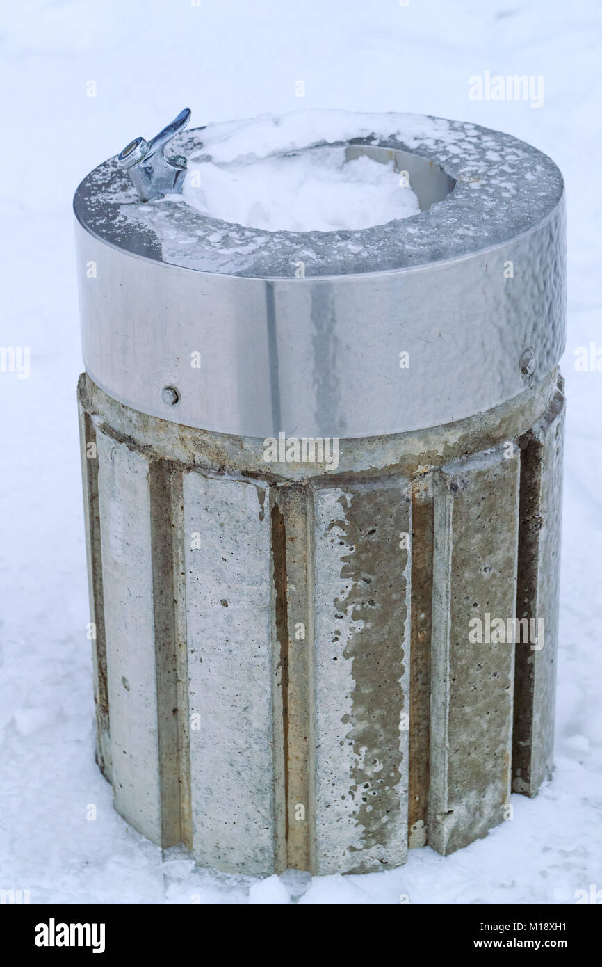 Distributeur d'eau gelé et neigé en parc public à l'hiver. Frozen creux en  rue Photo Stock - Alamy