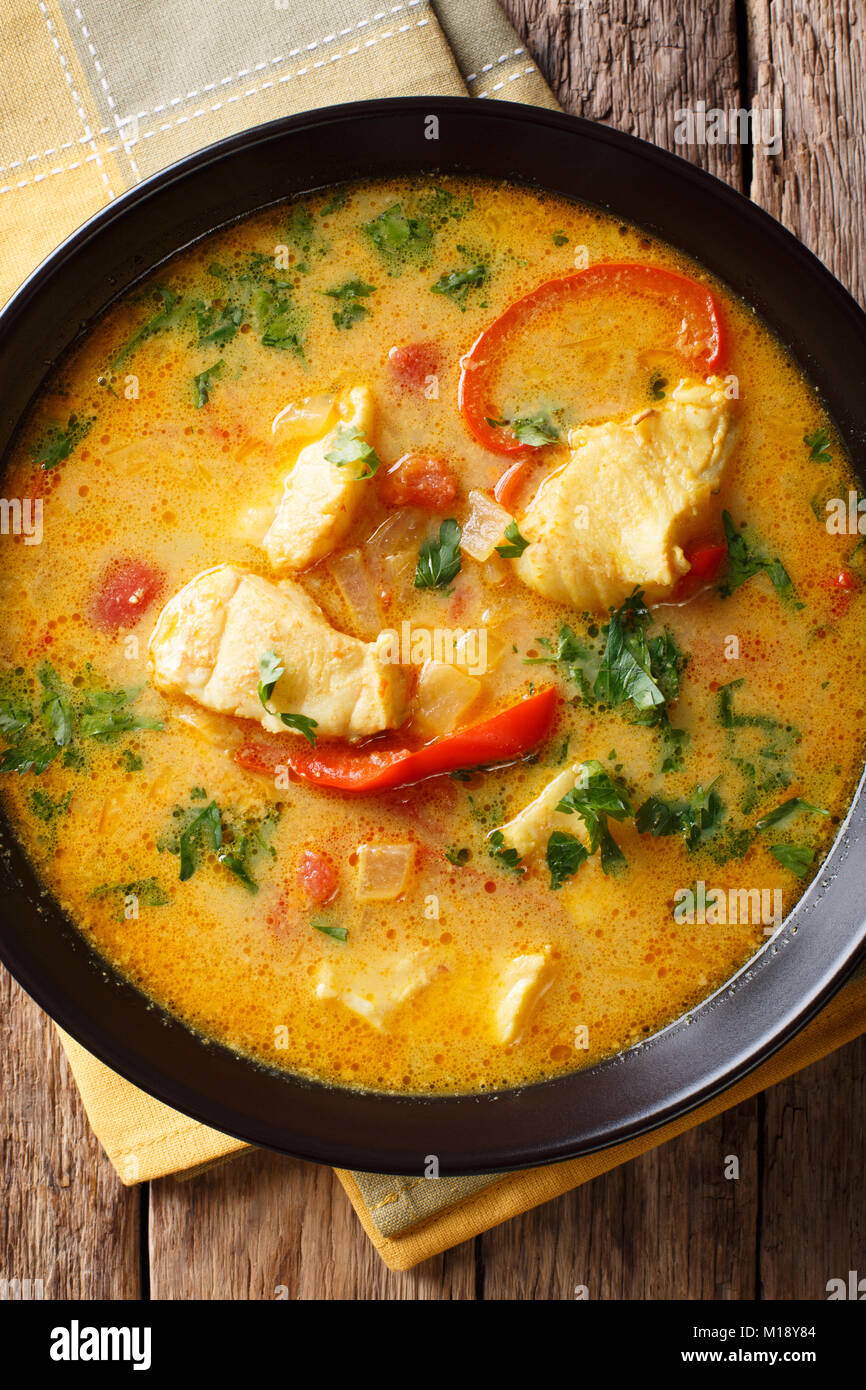 Le plat traditionnel brésilien Baiana Moqueca de poisson et poivrons dans une sauce coco délicatement sur une plaque sur une table. Vue supérieure verticale fro Banque D'Images