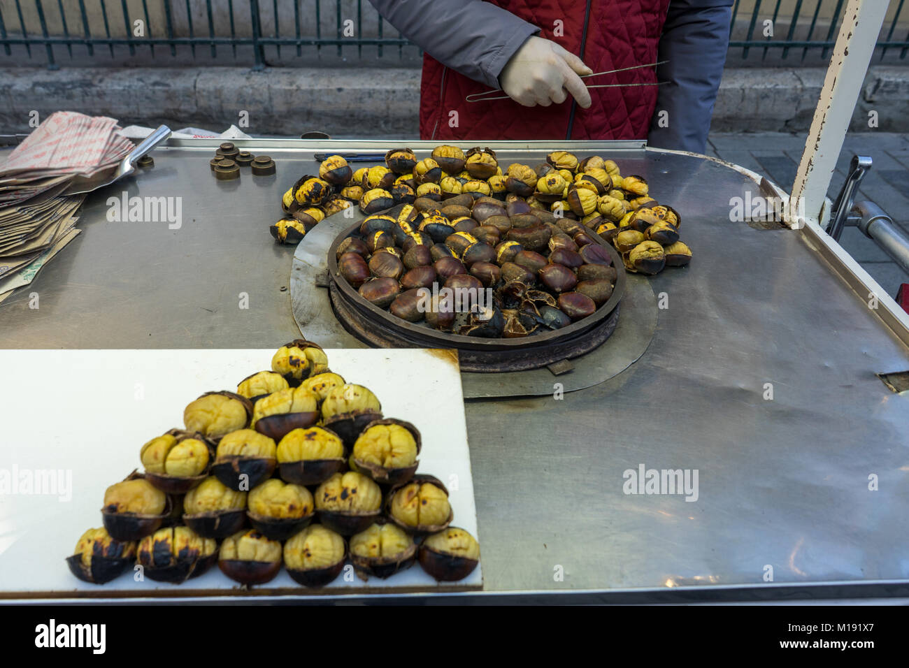 Les mains de l'homme la préparation de châtaignes grillées à la place Taksim, Istanbul, Turquie Banque D'Images